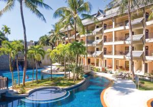 eine Luftansicht des Resorts mit 2 Pools und Palmen in der Unterkunft Radisson Resort and Suites Phuket in Kamala Beach