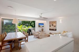 una cucina e un soggiorno con tavolo e sedie di The Cove Noosa - Apartment 13 a Noosa Heads