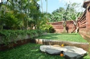 um jardim com uma pedra na relva em Kubu Manis Villa em Ubud