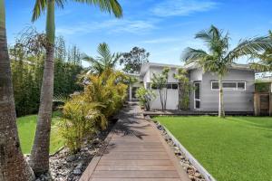 ein Haus mit Palmen und einem Gehweg in der Unterkunft Bamboo Beachhouse in Berrara