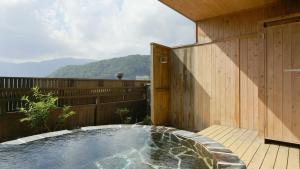 bañera de hidromasaje en la cubierta de una casa en Hotel Koryu en Fujikawaguchiko