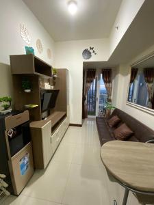 een woonkamer met een bank en een tafel bij TripleQ Room 2BR Vidaview Apartment in Makassar
