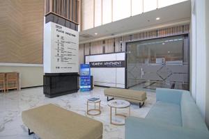 een lobby met banken en tafels in een gebouw bij TripleQ Room 2BR Vidaview Apartment in Makassar