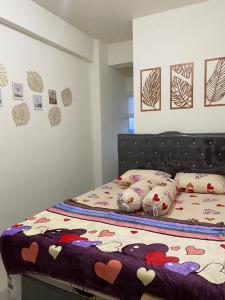 een slaapkamer met een bed met kussens erop bij TripleQ Room 2BR Vidaview Apartment in Makassar