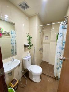 a bathroom with a toilet and a sink at TripleQ Room 2BR Vidaview Apartment in Makassar