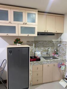 een keuken met een koelkast en een wastafel bij TripleQ Room 2BR Vidaview Apartment in Makassar