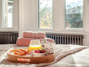 een dienblad met ontbijtproducten en sinaasappelsap op een bed bij West House in Wooler