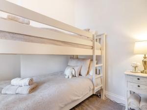 a bedroom with two bunk beds with towels and a desk at West House in Wooler