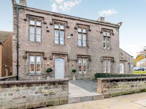 een oud bakstenen gebouw met een witte deur bij West House in Wooler