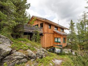 une maison en bois sur une colline avec des arbres dans l'établissement Chalet Alpenpark Turracherhöhe 4, à Turracher Höhe