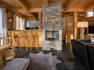 a living room with a fireplace in a log cabin at Chalet Alpenpark Turracherhöhe 2 in Turracher Hohe