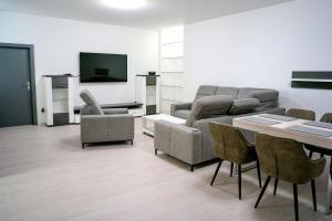 - un salon avec un canapé, une table et des chaises dans l'établissement AH Lahoda, à Košice