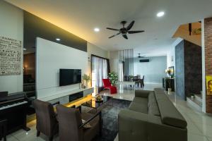 un salon avec un canapé et un piano dans l'établissement CloClo Villa - Truly Cuti-Cuti Melaka (24pax), à Malacca