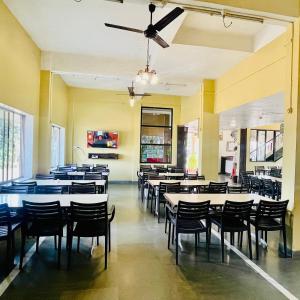 a dining room with tables and chairs at Hotel Manik Moti in Lonavala