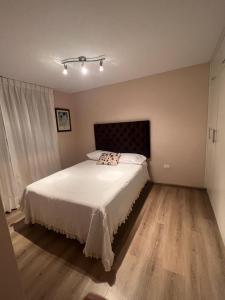 ein Schlafzimmer mit einem großen Bett mit weißer Bettwäsche in der Unterkunft Ilo, lindo depa exclusivo amoblado con cochera in Ilo