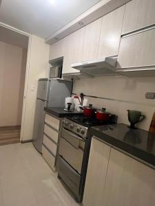 a kitchen with a stove and a refrigerator at Ilo, lindo depa exclusivo amoblado con cochera in Ilo