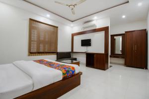 a bedroom with a bed and a flat screen tv at FabExpress Yuvan in Naiāpura