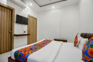 a bedroom with a bed and a television on a wall at FabExpress Yuvan in Naiāpura