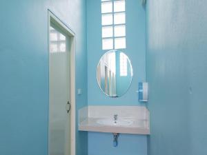 La salle de bains bleue est pourvue d'un lavabo et d'un miroir. dans l'établissement Khao Sok Backpacker Hostel, à Khao Sok