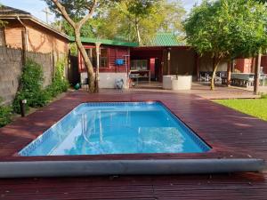 a swimming pool on a deck next to a house at Cabins Sodwana Bay - antibootika in Sodwana Bay