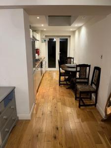 a kitchen and dining room with a table and chairs at Chiswick two minutes station home in London