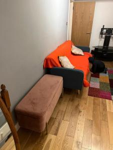 a bedroom with a bed with an orange blanket at Chiswick two minutes station home in London