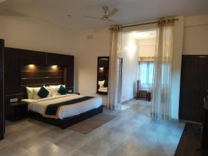 - une chambre avec un grand lit dans l'établissement Hotel Holiday Highlights, à Rāmnagar