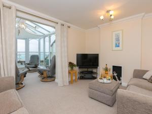 a living room with a couch and a television at Laurellie in Carbis Bay