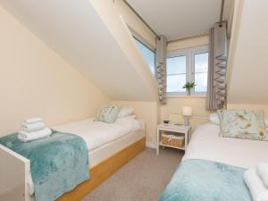 a attic bedroom with two beds and a window at Laurellie in Carbis Bay