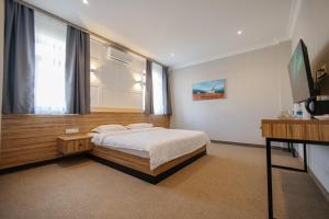 a bedroom with a bed and a television in it at 281 Hotel in Bishkek