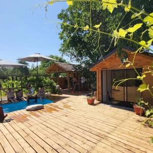 un patio con terrazza in legno con una casa di Nada vineyard a Rakhat