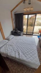 um quarto com uma grande cama branca e uma janela em Nada vineyard em Rakhat