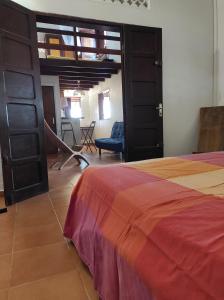ein Schlafzimmer mit einem Bett und ein Zimmer mit Stühlen in der Unterkunft Tikoté Chwit point 1 in Cayenne