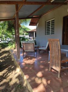 eine Terrasse mit 2 Holzstühlen und einem Tisch in der Unterkunft Tikoté Chwit point 1 in Cayenne