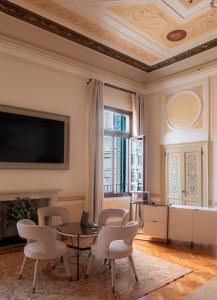 sala de estar con mesa, sillas y TV en Palazzo Maria Formosa, en Venecia