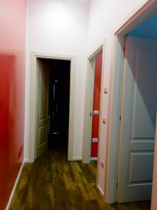 un corridoio vuoto con due porte e pavimenti in legno di Hotel Ausonia a Napoli