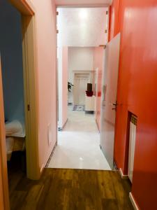 un pasillo con paredes de color naranja y suelo blanco en Hotel Ausonia en Nápoles