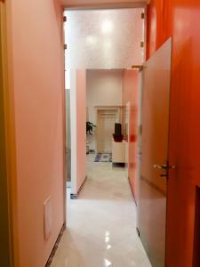 un corridoio di un ufficio con pareti arancioni e pavimenti piastrellati di Hotel Ausonia a Napoli