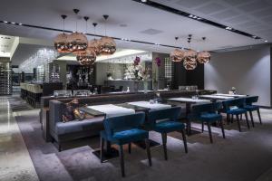 a restaurant with tables and chairs and a couch at Van Der Valk Hotel Zwolle in Zwolle