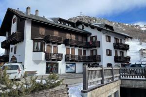 a building with balconies and a car parked in front of it at Grazioso appartamento vicino al centro in Livigno