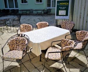 una mesa y sillas con una mesa y sillas blancas en myMINGA4 - Hotel & serviced Apartments en Múnich