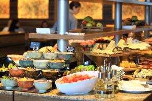 a buffet line with plates of food and bowls of food at Marco Polo Hotel Gudauri in Gudauri