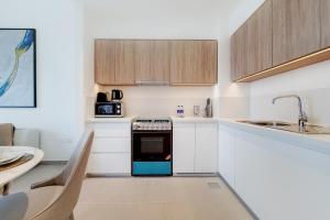 a kitchen with white cabinets and a blue oven at Primestay - Executive Residences in Dubai Hills Estate in Dubai
