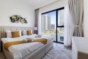 a bedroom with a large bed and a large window at Primestay - Executive Residences in Dubai Hills Estate in Dubai