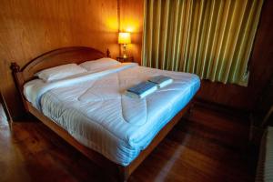 a bedroom with a bed with a book on it at SeeSea Thai wooden house on beachfront in Prachuap Khiri Khan