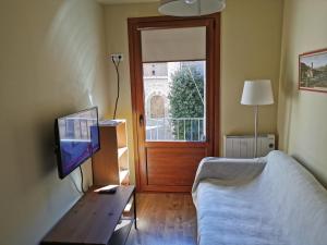 ein Wohnzimmer mit einem Sofa, einem TV und einem Tisch in der Unterkunft Apartaments Sant Miquel in Sant Joan de les Abadesses