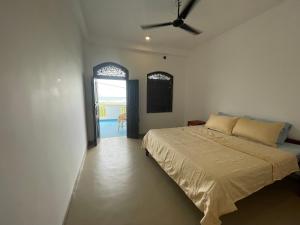 a bedroom with a bed with a ceiling fan at Funky Sol - Sunset Rooftop Bar, Hotel & Restaurant in Weligama