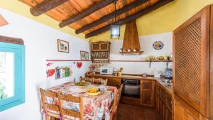 a kitchen with a table with chairs and a sink at El Acebuchal - Casa Rosa Frigiliana by Ruralidays in Frigiliana