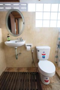 uma casa de banho com um WC, um lavatório e um espelho. em SeeSea Thai wooden house on beachfront em Prachuap Khiri Khan