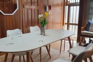 two white tables with wine glasses and flowers on them at JJ House Gwangan Beach 드론쇼 매주토요일8시10시 in Busan